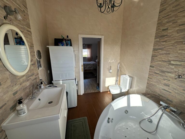 Gran dormitorio abuhardillado con zona vestidor y baño en suite con bañera de hidromasaje.
